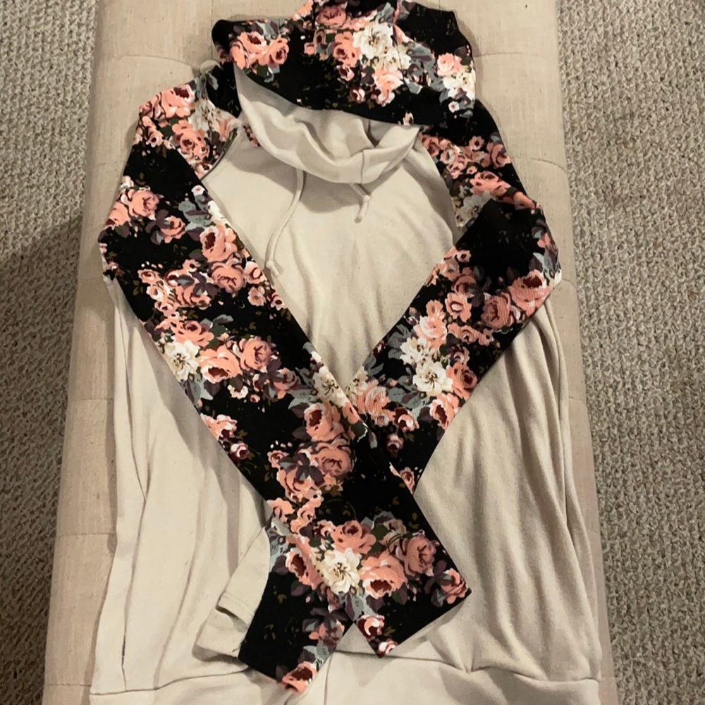 Tan sweater with flowered sleeves and hood.